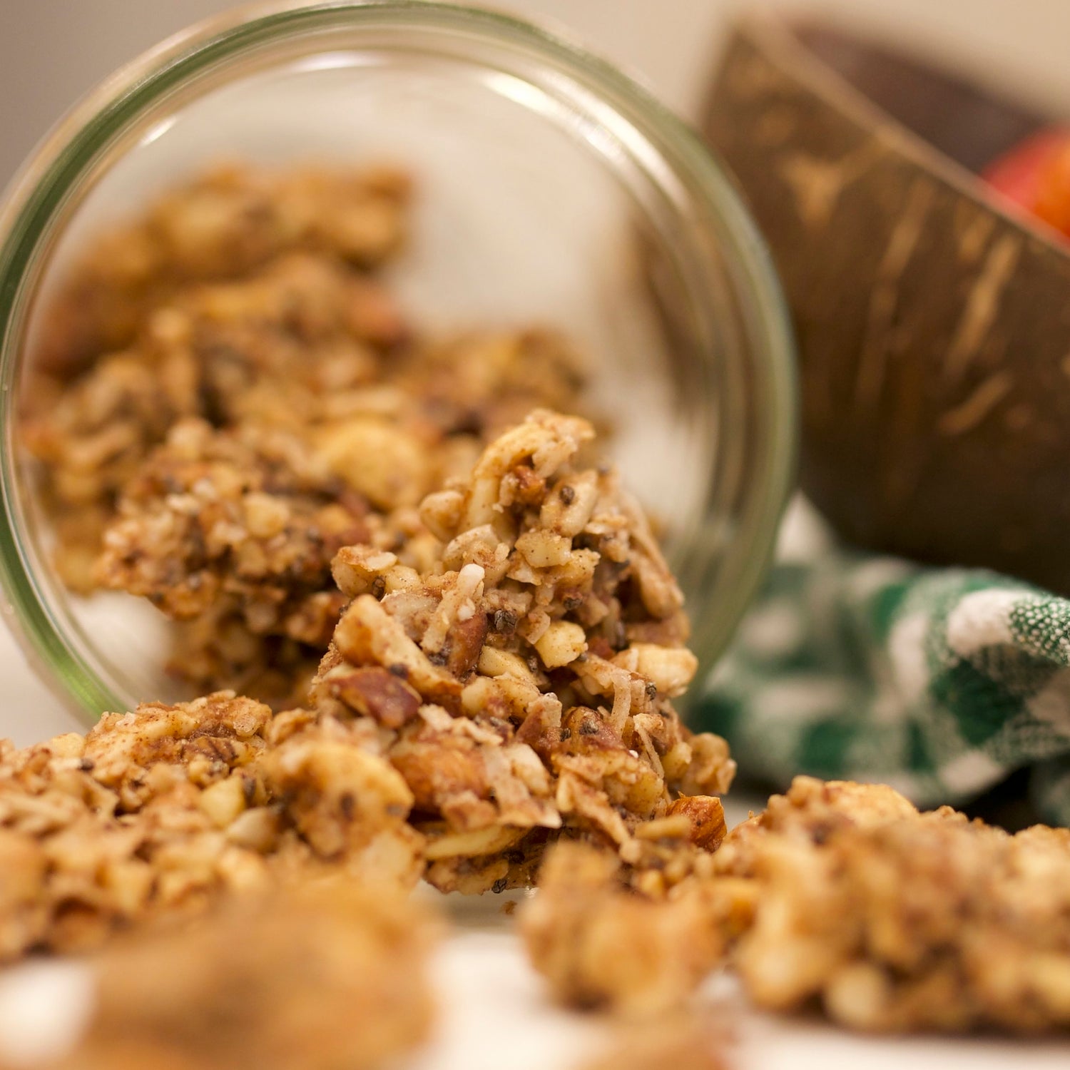 Grain-free vanilla almond crunch granola spilling out of a glass mason jar